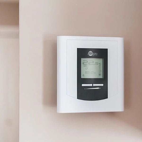 Wall Mounted Digital Thermostat in a Room A wall-mounted digital thermostat on the side of a room, allowing for temperature control and monitoring of the indoor environment