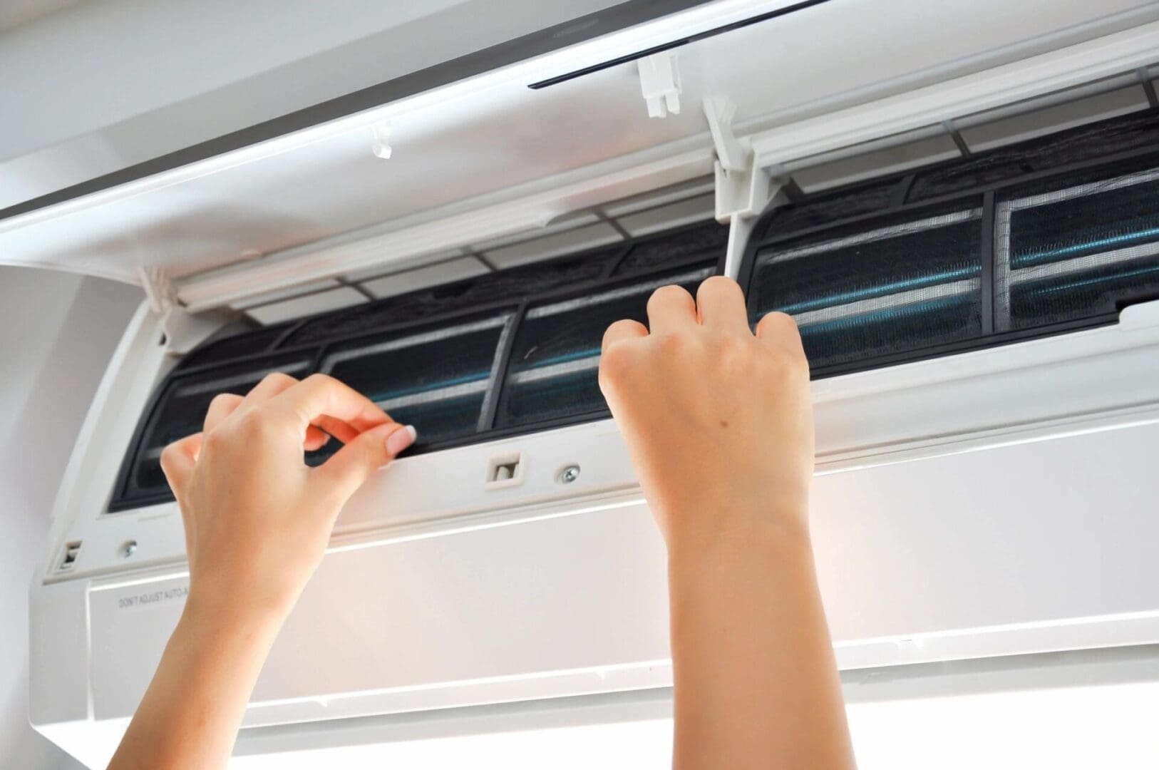 Air Conditioning Repair Technician Working on an AC Unit Inside An air conditioning repair technician is working on an air conditioner inside, likely performing maintenance or repairs