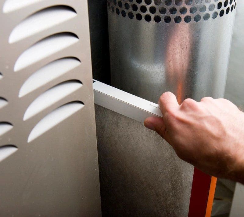 A person is holding the handle of an air conditioner.