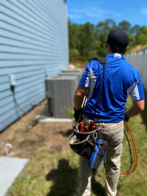 HVAC Technician Carrying Tools to Repair a Heating Unit An HVAC technician, dressed in a uniform, is carrying tools to repair a heating unit, prepared to troubleshoot or replace components for efficient operation in Callahan, FL