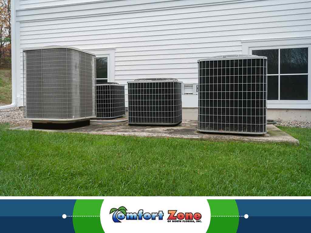 Group of Air Conditioners Sitting in the Grass A group of air conditioning units are sitting in the grass, likely positioned for cooling purposes or awaiting installation