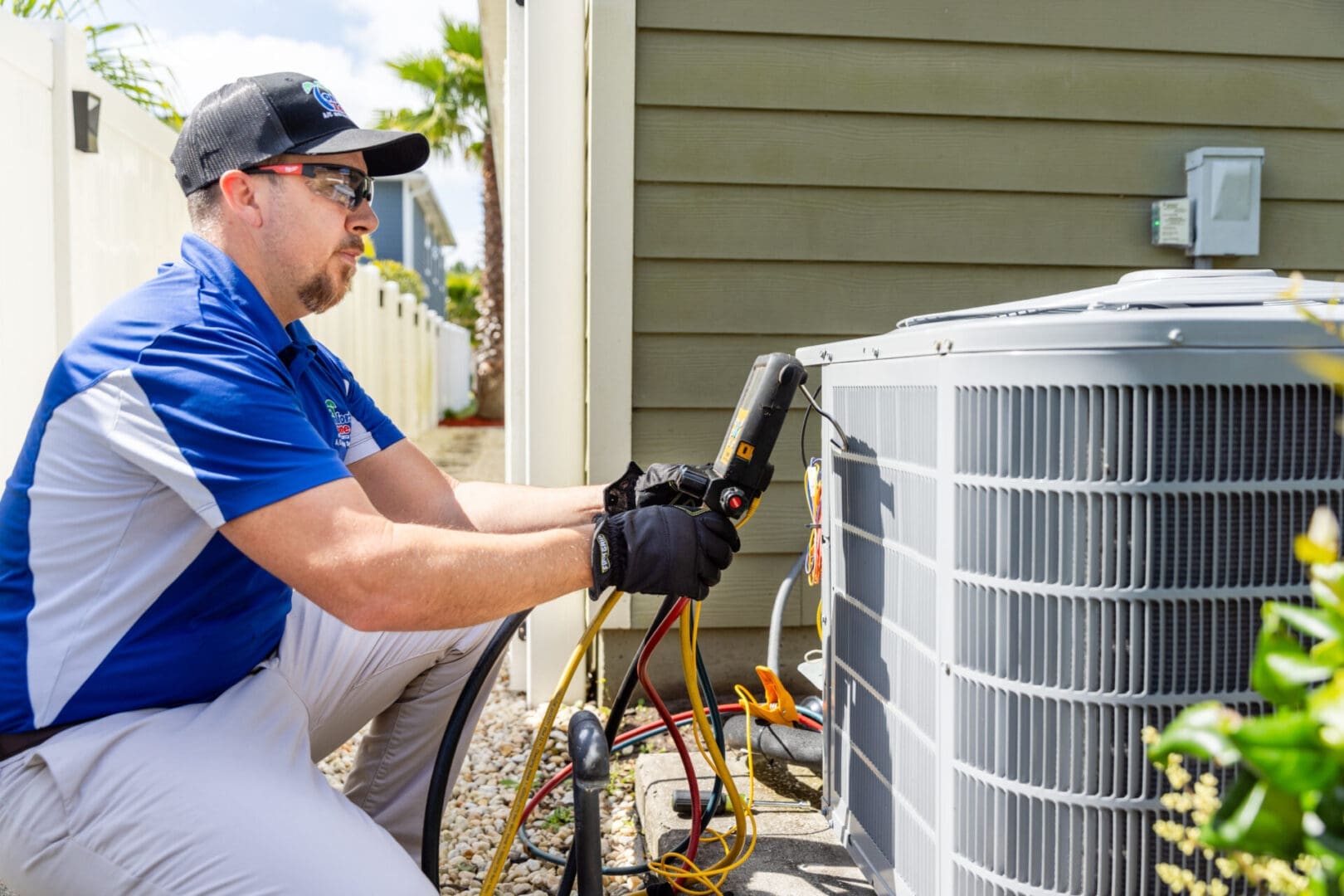 Air Conditioning Service Technician Inspecting Unit Outside a Home in Yulee, Florida An air conditioning service technician is inspecting an outdoor air conditioning unit in front of a residential home in Yulee, Florida, ensuring the system is functioning properly.