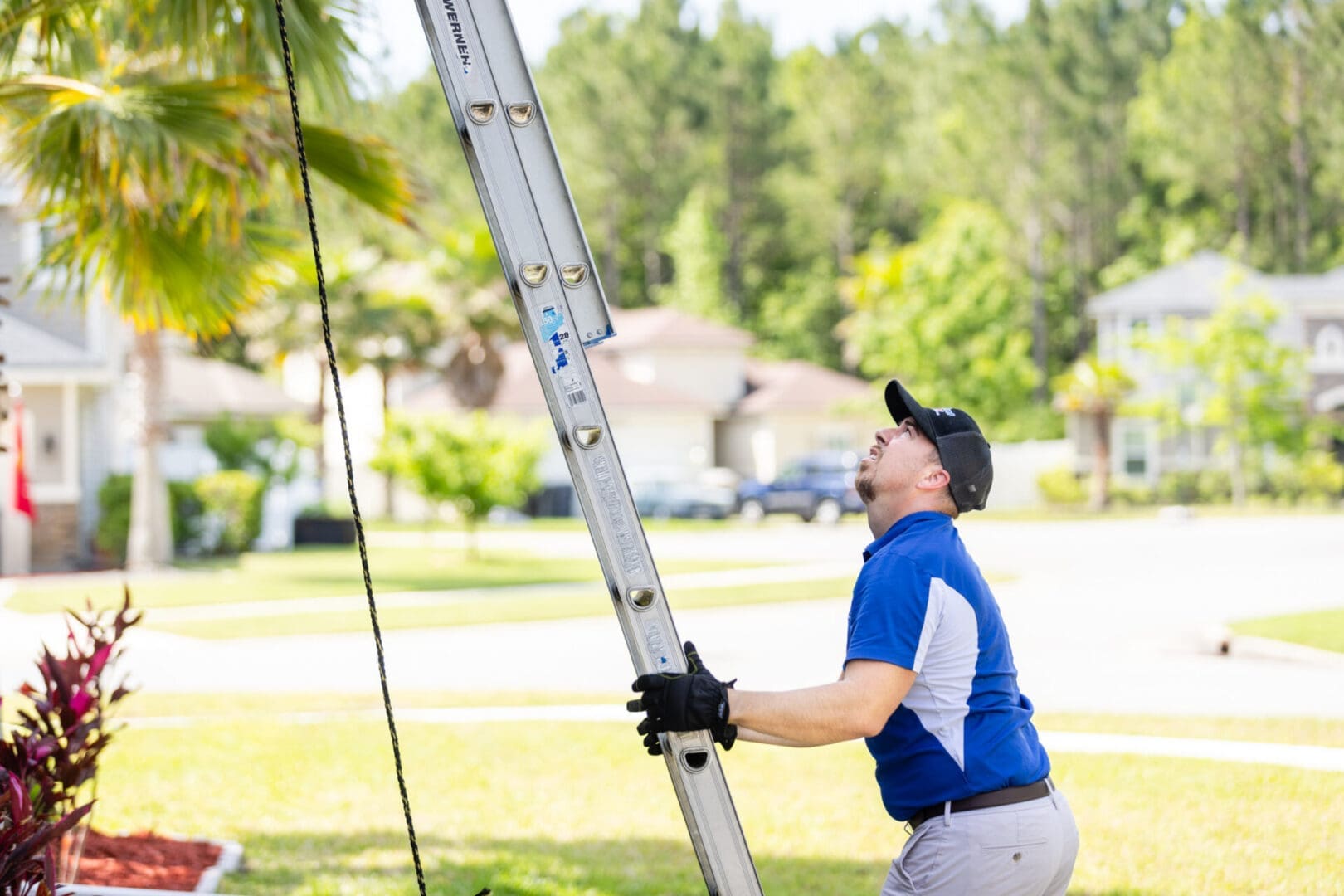 Home Ventilation Inspection A HVAC Service Technician holding onto a ladder to reach the top of a house to make a ventilation repair on a exhaust system.