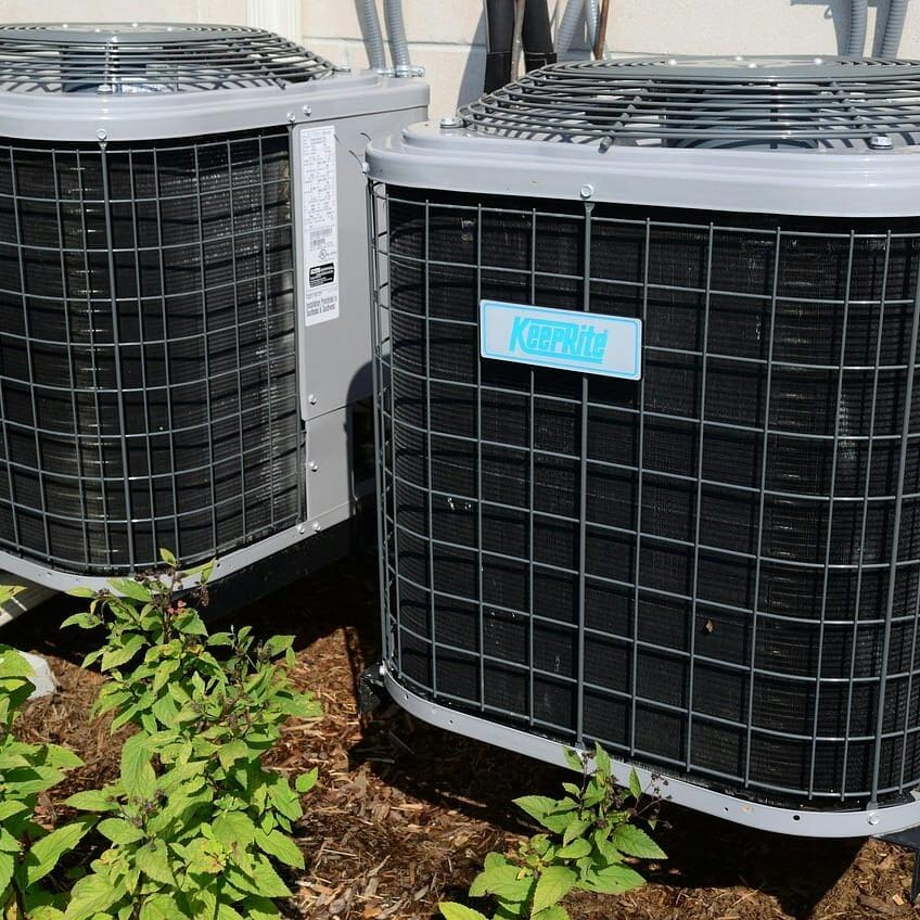 Two air conditioners are elevated off the ground to prevent ice build-up around the condenser, ensuring proper airflow and function in Yulee Florida