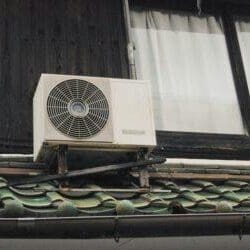 A small ductless air conditioner on the side of a house.