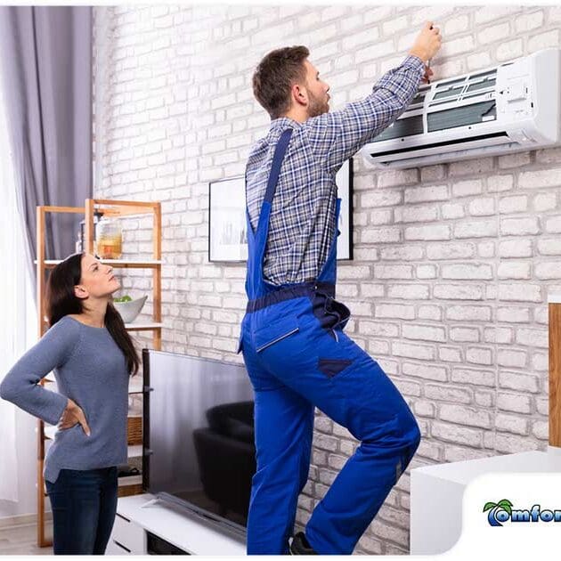 Ductless contractor services A AC repairman is installing a ductless mini split air conditioning unit while the homeowner points out the spot for proper placement