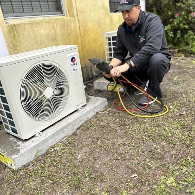 Man Working on an Air Conditioner Outside A man is working on an air conditioner outside, inspecting or repairing the unit to ensure it is functioning properly