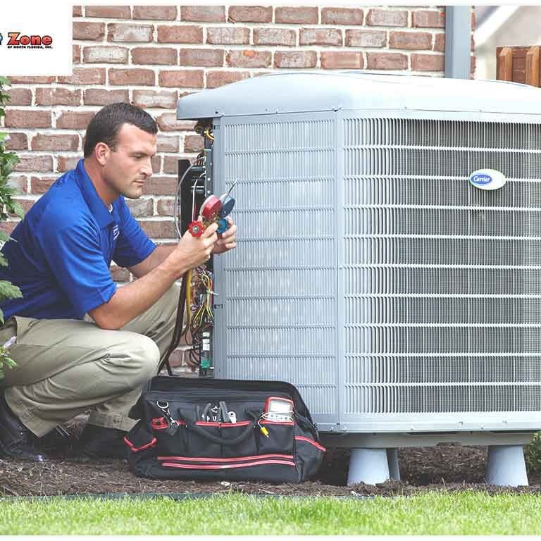 A Service man is working on a Carrier air conditioner, performing maintenance or repairs to ensure the unit operates efficiently