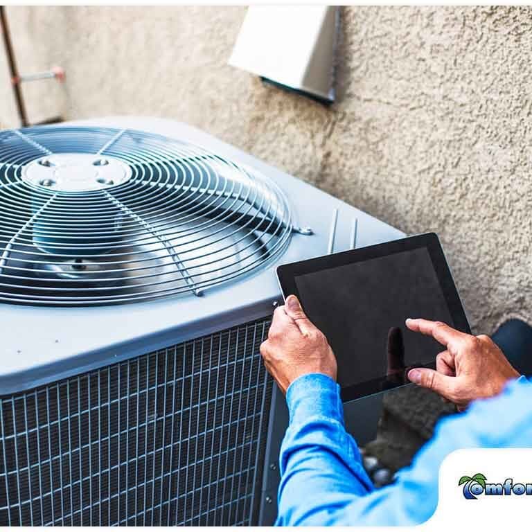 HVAC Tech Working on Fall Maintenance Service An HVAC technician is performing fall maintenance service on a heating and cooling system, ensuring it runs efficiently for the colder months