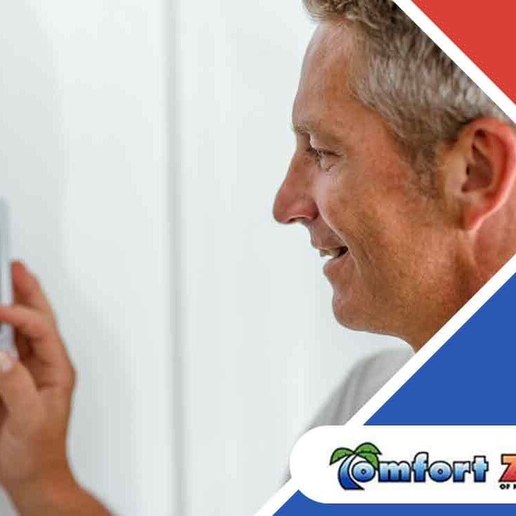An AC repairman is adjusting the temperature on a thermostat to ensure optimal comfort and system efficiency