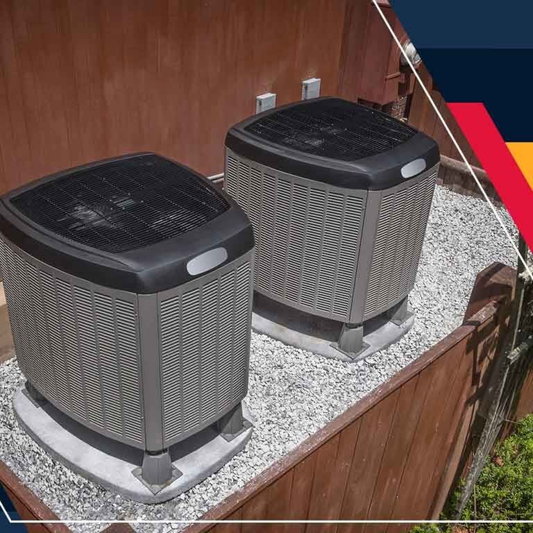 Heat Pump Condensers Two air conditioners are sitting on top of a deck.