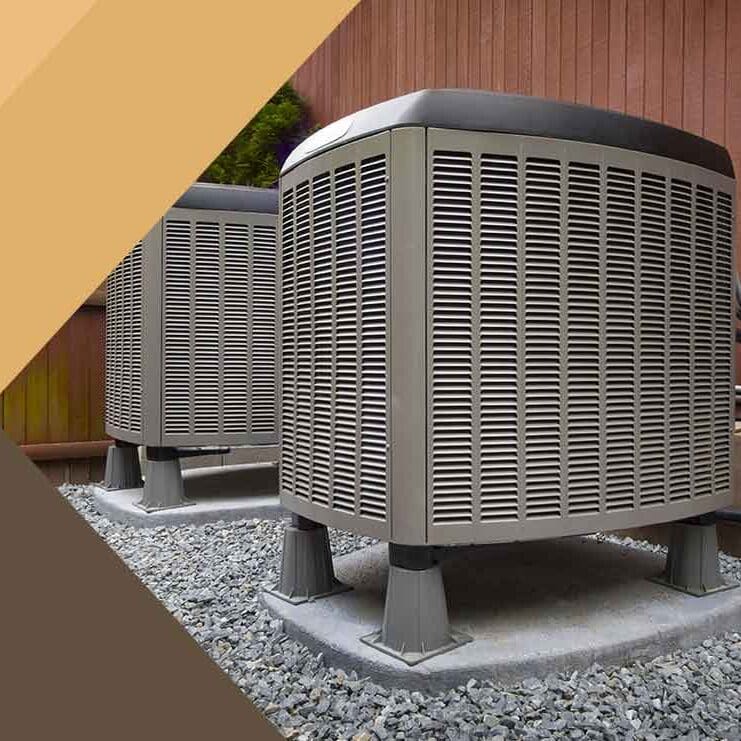 Two air conditioning units are elevated on a gravel surface, providing cooling to the surrounding area with clear space for proper airflow