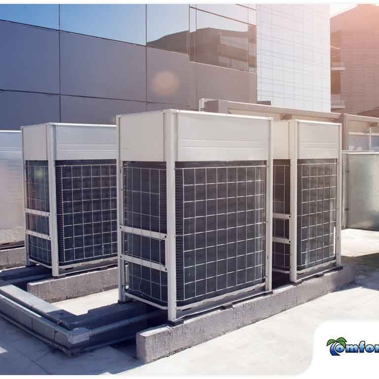 Three rooftop air conditioning units are installed on a commercial building, providing cooling for the structure