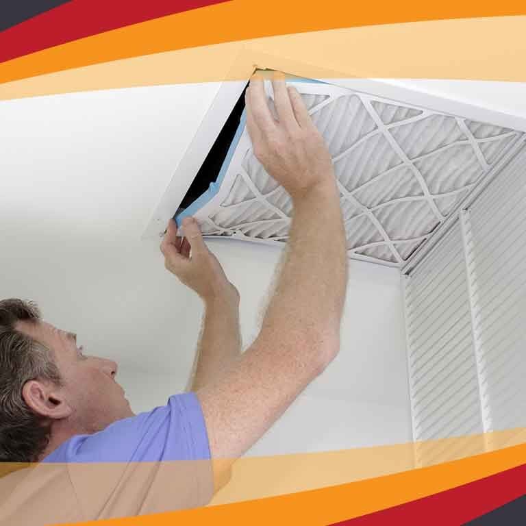 An HVAC technician is replacing an air conditioning filter in the ceiling, ensuring the system's air quality and efficiency