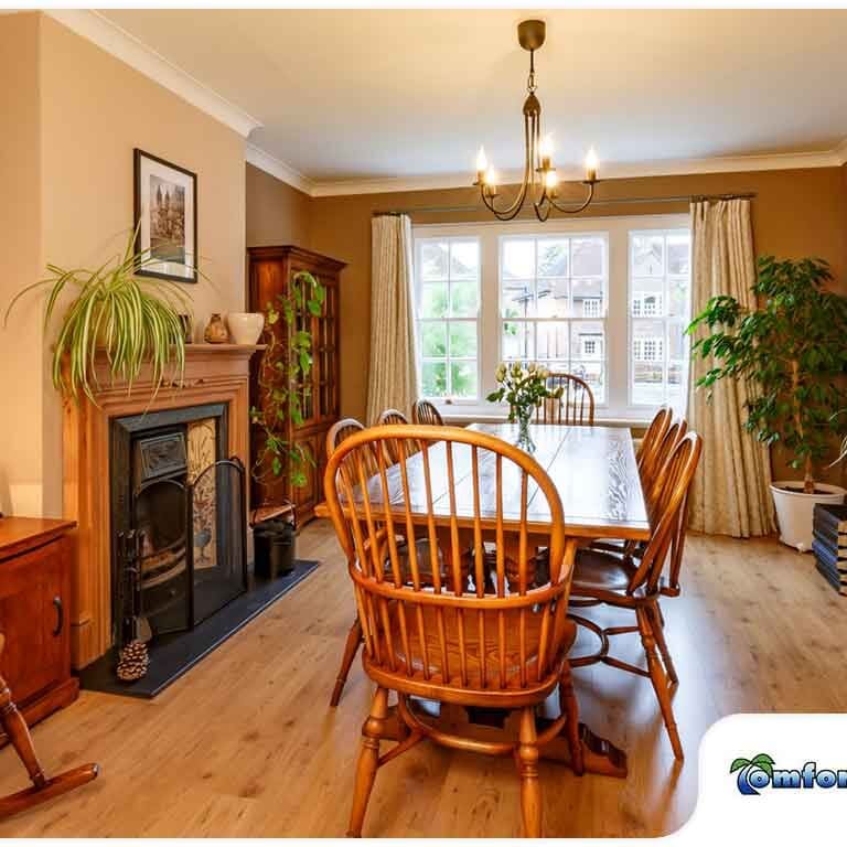 A cozy dining room featuring wooden chairs, a dining table, and a warm fireplace creating a comfortable space